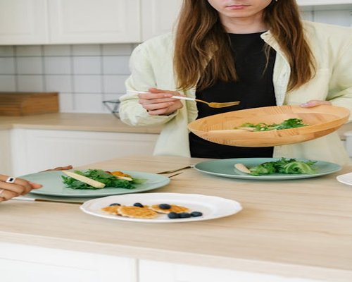 Person preparing healthy vegetable salad in kitchen