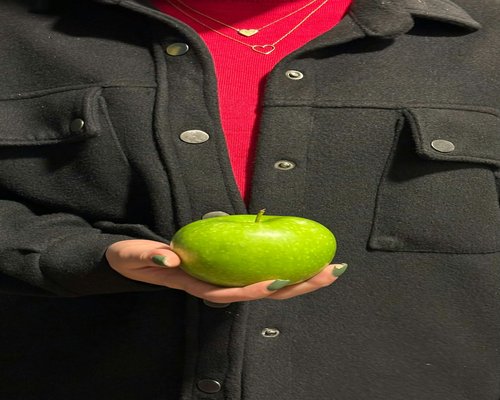 Person holding fresh green apple implying health choice